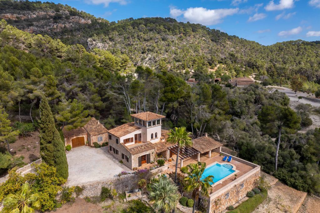 A luxurious transport van parked near a scenic mountain retreat, a remote villa, or a special event venue in Mallorca, showcasing exclusivity and comfort.